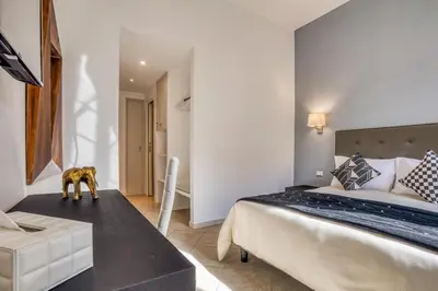 a bedroom with a bed and a dog standing on a table at Ada Rooms in Rome