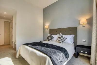 a bedroom with a large bed with white sheets and pillows at Ada Rooms in Rome