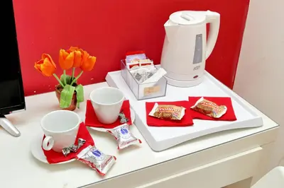 a table with a coffee maker and cups and flowers at Affittacamere Alessia&Calliope in Rome