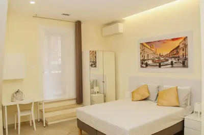 a white bedroom with a bed and a table at DOMUS DIVI - appartamento nel cuore di Roma in Rome