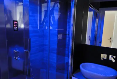 a blue bathroom with a shower and a blue sink at Jazz Style in Rome