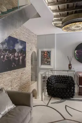 a living room with a couch and a brick wall at BDB Rooms Margutta in Rome