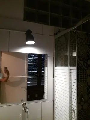 a person taking a picture of a mirror in a bathroom at Roma Trastevere Station in Rome