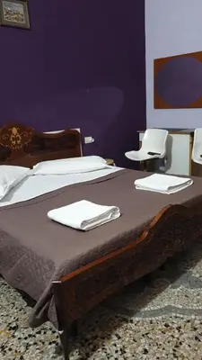 a bedroom with a bed with two white chairs at guesthouse ava roma in Rome