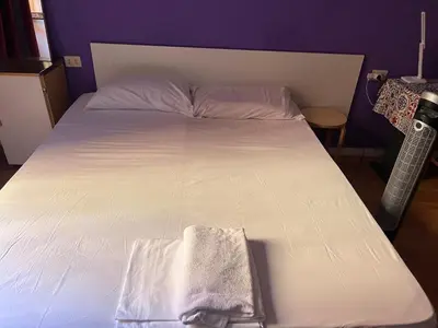 a bed with a white bedspread and a towel on it at guesthouse ava roma in Rome