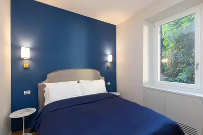 a blue bedroom with a bed and a window at Donatello Loft in Rome