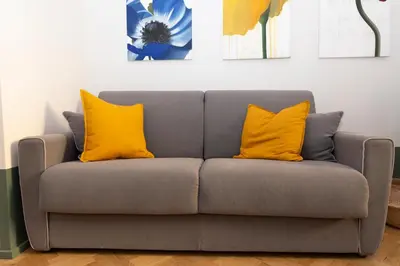 a gray couch with two yellow pillows on it at Donatello Loft in Rome