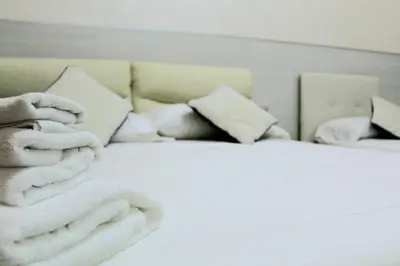 a bed with a pile of towels on it at Oscar suite home in Rome