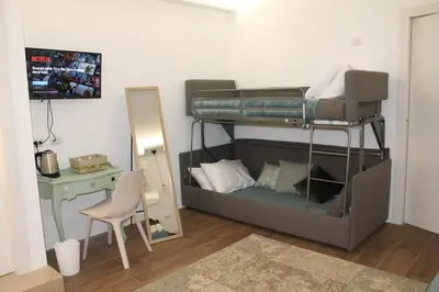 a bedroom with a bunk bed with a desk and a mirror at Nannarè Guest House in Rome