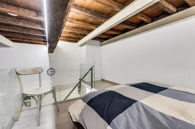 a bedroom with a bed and a chair at Rome Historic Center LOFT in Rome