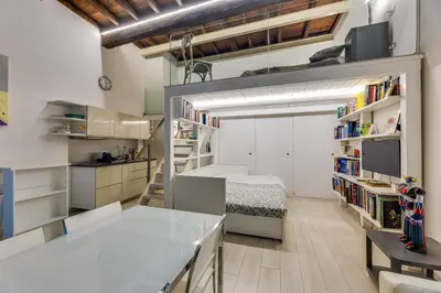 a kitchen with white cabinets and a bunk bed at Rome Historic Center LOFT in Rome