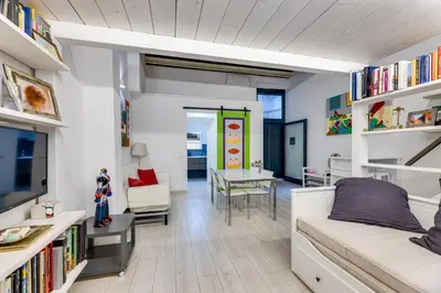 a room with a bed and a living room with bookshelves at Rome Historic Center LOFT in Rome