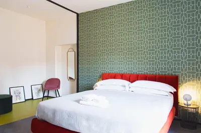 a bedroom with a large bed with a red headboard at TrastevereHome - Santa Cecilia in Trastevere with Balcony in Rome