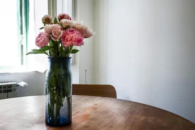 a vase filled with pink flowers sitting on a table at TrastevereHome - San Cosimato View on Trastevere Square in Rome