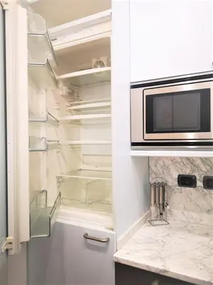 a kitchen with a microwave and a refrigerator at Trevi Nice Holiday - Luxury Apartment in Rome