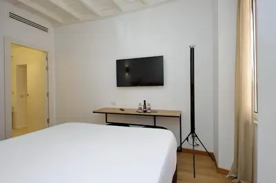 a bedroom with a bed and a television on the wall at Youroom Vite in Rome