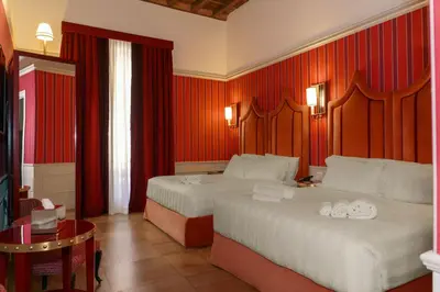 a hotel room with two beds and red walls at Il Campo Marzio in Rome