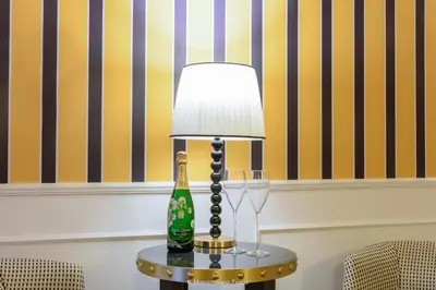 a lamp on a table with a bottle and wine glasses at Il Campo Marzio in Rome