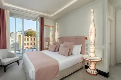 a bedroom with a bed and a chair and a window at Room Mate Collection Gran Filippo, Rome-Fontana di Trevi in Rome
