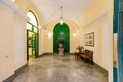 a hallway with a green door and a table at A World Aparts - 61 Margutta in Rome
