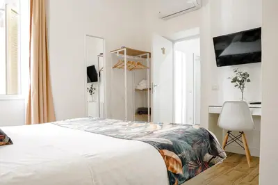 a white bedroom with a bed and a chair at Da Fede in Rome
