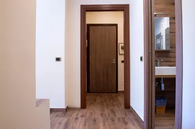 a hallway with a wooden door and a sink at JSK Suite in Rome