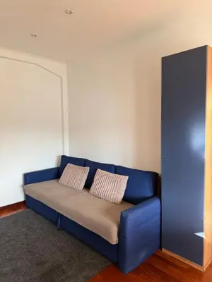 a blue couch with two pillows on it in a room at Home of Joy - Vatican in Rome