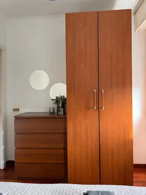 a bedroom with a wooden cabinet and a dresser at Home of Joy - Vatican in Rome