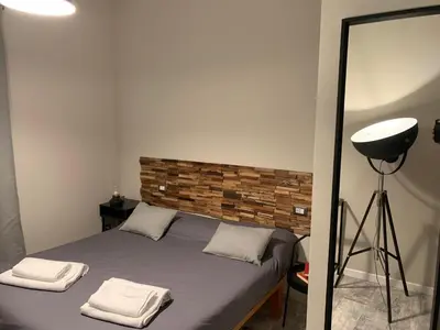 a bedroom with a bed with a mirror and a lamp at B&B Nonna Marcella in Rome