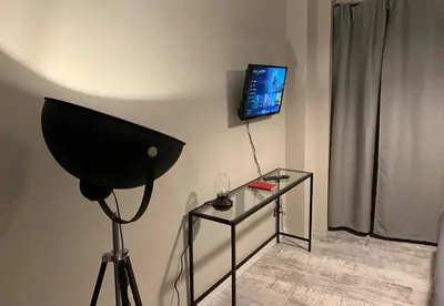 a room with a television and a glass table with a lamp at B&B Nonna Marcella in Rome
