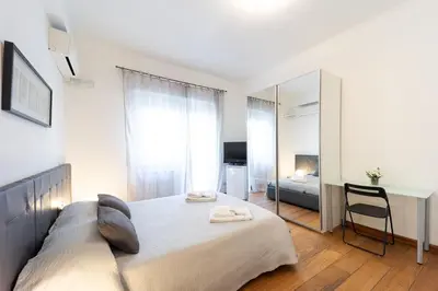 a bedroom with a large bed and a mirror at Mirabella Apartment in Rome