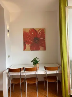 a table and chairs in a room with a painting at Milazzo Luxury Home roma in Rome
