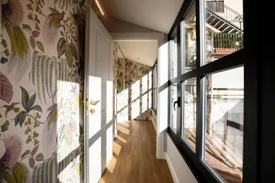 a hallway with windows and floral wallpaper at Vicario Suites in Rome