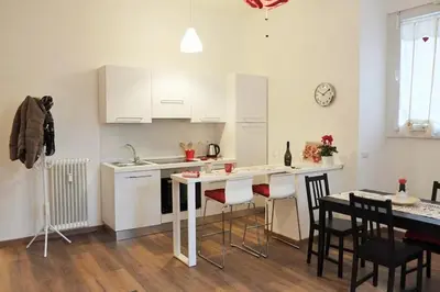 a kitchen with white cabinets and a table and chairs at Trastevere Sweet Home in Rome