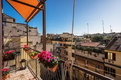 a balcony with flowerpots and balconies with buildings at FRESH HOUSE MONTI in Rome