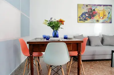 a dining room table with chairs and a vase of flowers at Martino Delightful Apartment in Rome