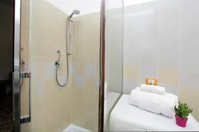 a bathroom with a shower and a toilet with towels at Martino Delightful Apartment in Rome