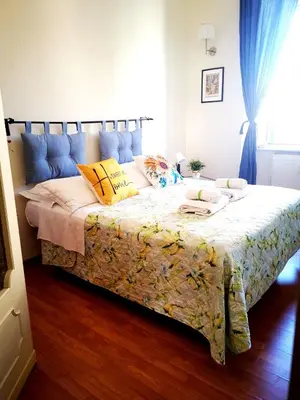 a bedroom with a large bed with yellow and blue pillows at St. Joseph Apartment 47 in Rome