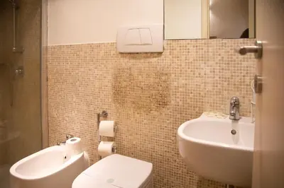 a bathroom with a sink and a toilet and a mirror at Il Rifugio di Trastevere in Rome