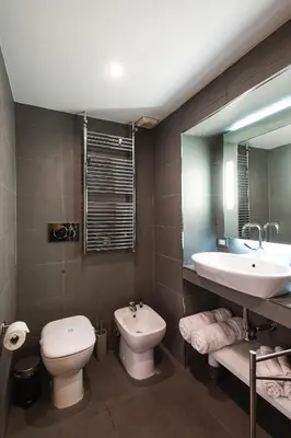 a bathroom with a sink and a toilet and a mirror at EBL LUXURY HOME in Rome