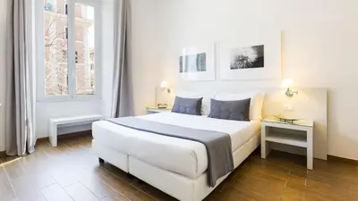 a bedroom with a large white bed and a window at Rest Guesthouse in Rome
