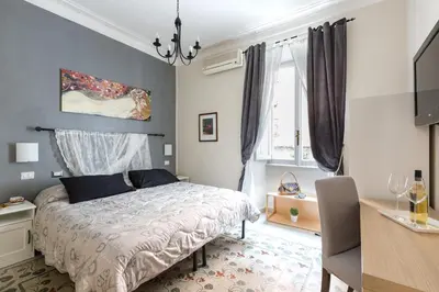 a bedroom with a bed and a desk and window at B&B Calamatta in Rome