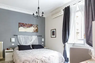 a bedroom with a bed and a chandelier at B&B Calamatta in Rome
