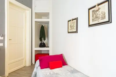 a bedroom with a bed with two red pillows on it at B&B Calamatta in Rome