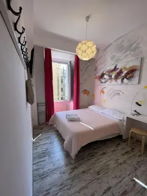 a bedroom with a bed and a table and a window at Moshi Moshi in Rome