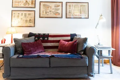 a couch with patriotic pillows in a living room at Arc Trilussa 44 in Rome