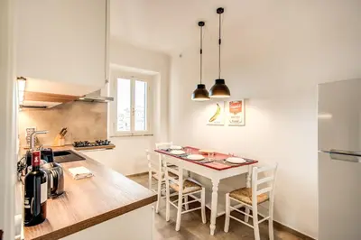 a kitchen with a table and chairs in a room at Cavour Attic with terrace in Rome