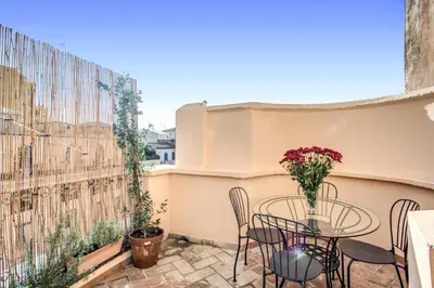 a patio with a table and chairs on a balcony at Cavour Attic with terrace in Rome