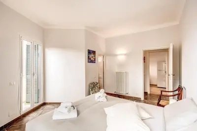 a white bedroom with a large bed with two towels at Cavour Attic with terrace in Rome