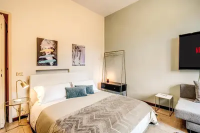 a bedroom with a large bed and a tv at DOWNTOWN SRL - Borghese Green in Rome